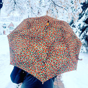 woman holding a lightweight, portable japarra sun umbrella parasol in Aspen to help her to block the sun's damaging UV rays that cause burning, premature aging and skin cancer.